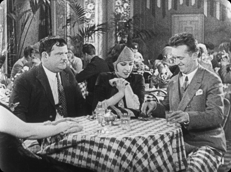 Stan entertains his date as Ollie looks suspiciously on in Their Purple Moment