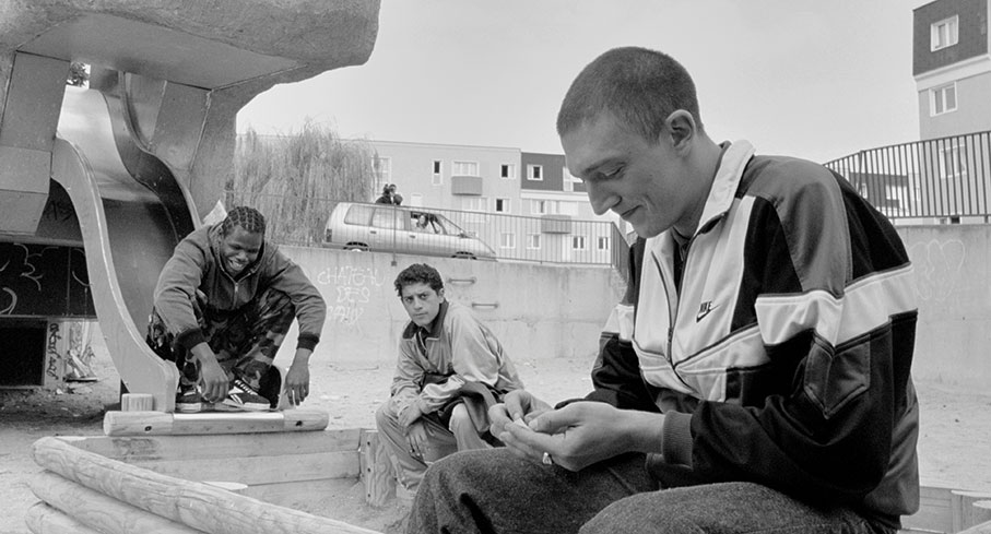 Hubert and Vinz are amused by Saïd's tales as a TV crew tries to film them