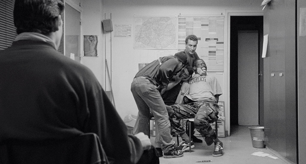 Hubert and Vinz are amused by Saïd's tales as a TV crew tries to film them