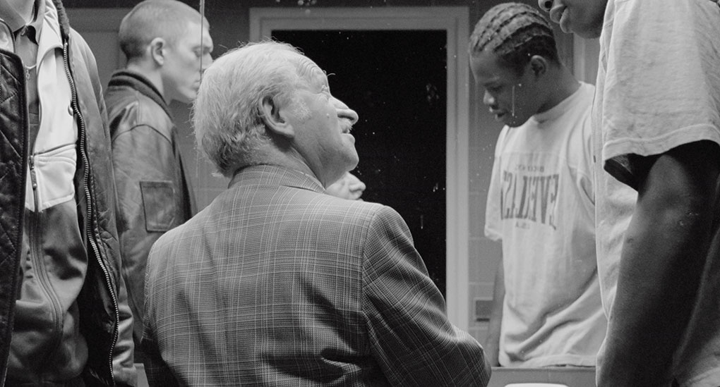 An old man tells the three friends a story in a public toilet