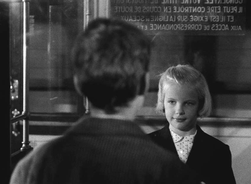 The two children face each other from the carriages of different trains