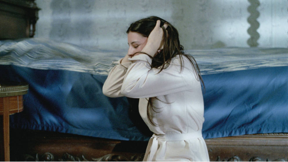 Hélène reacts to the anguished screams of a victim she has procured for Catherine